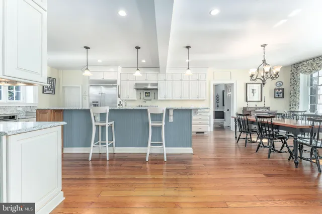 a bedroom with a bed a chandelier and dresser