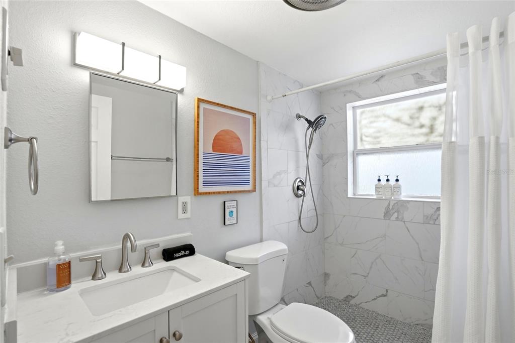 2311 Bay Boulevard Indian Rocks Beach, FL 33785 - Photo 27 of 80 a bathroom with a toilet sink shower and mirror