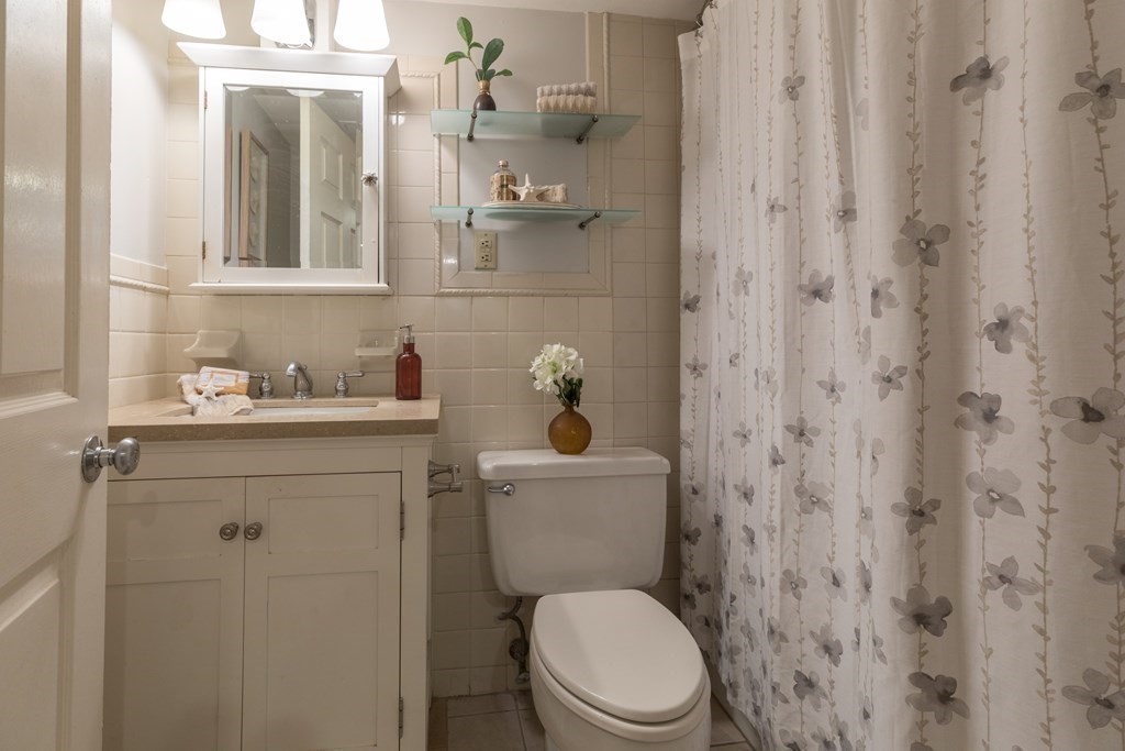 17 Gloucester Street, Unit A Boston, MA 02116 - Photo 16 of 20 a bathroom with a sink a toilet and shower curtain