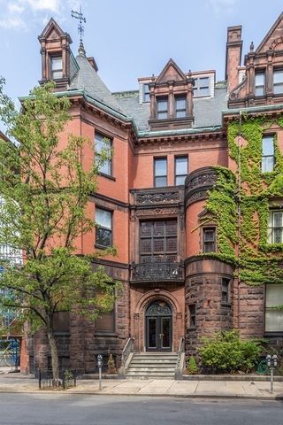 a front view of a building with a garden and plants