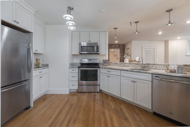 a kitchen with stainless steel appliances a refrigerator sink and microwave