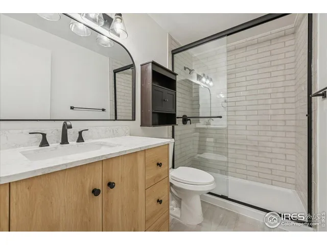 a bathroom with a granite countertop sink toilet and shower