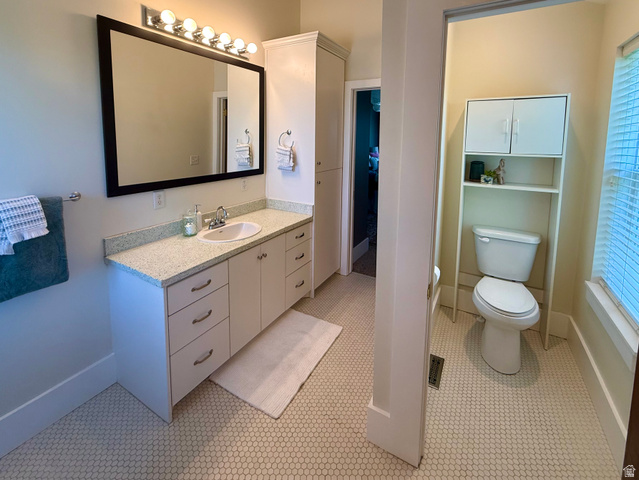 776 Canyon Road Hyde Park, UT 84318 - Photo 37 of 57 Bathroom featuring a white vanity with an undermount sink, a countertop with light flecking, and a large framed mirror with overhead lighting