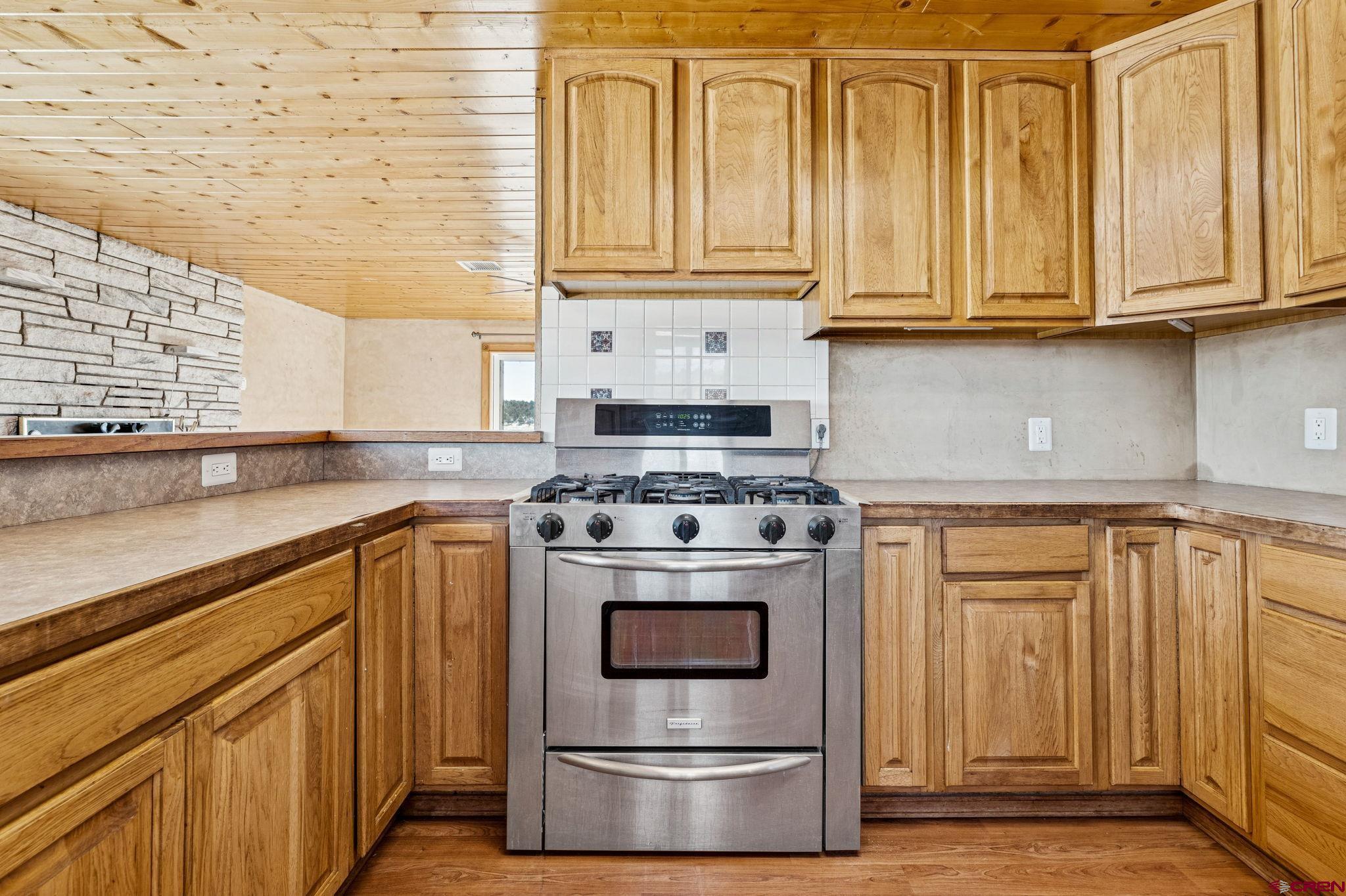 124 Meadow Road Ignacio, CO 81137 - Photo 24 of 37 a kitchen with stainless steel appliances granite countertop a stove a sink and a microwave