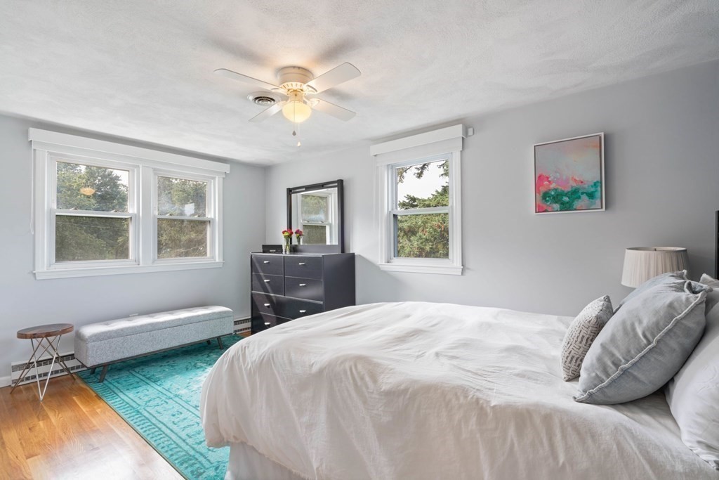 4 Rayner Circle Stoneham, MA 02180 - Photo 11 of 27 a bedroom with a bed a chandelier and windows