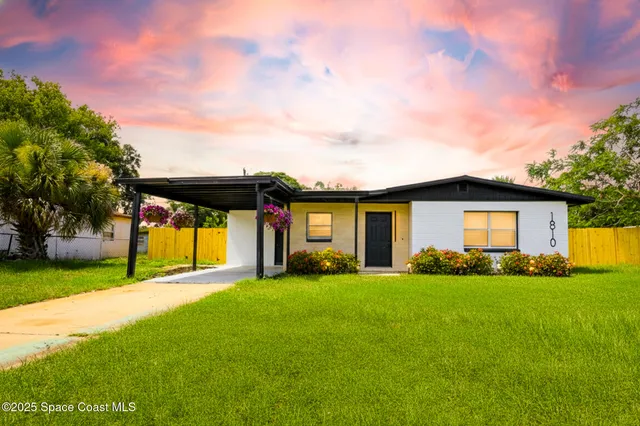 a view of a yard in front of a house with large tree
