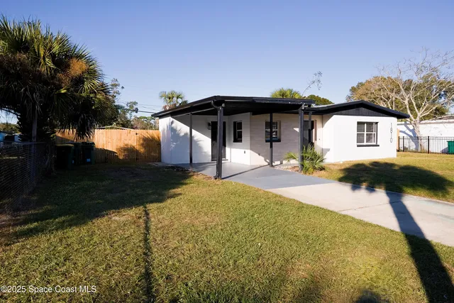 a view of a house with backyard and trees