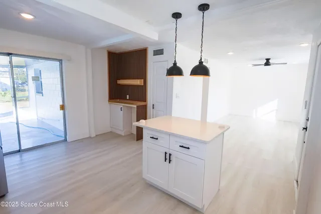 a kitchen with kitchen island a sink a stove a refrigerator and cabinets