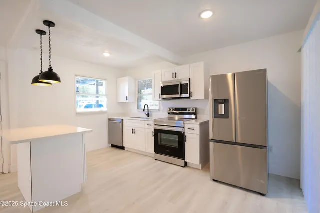 a kitchen with a refrigerator stainless steel appliances and cabinets