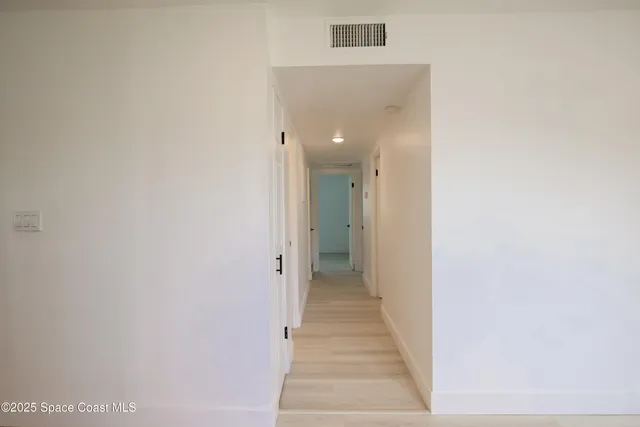 a view of a hallway with the wooden floor