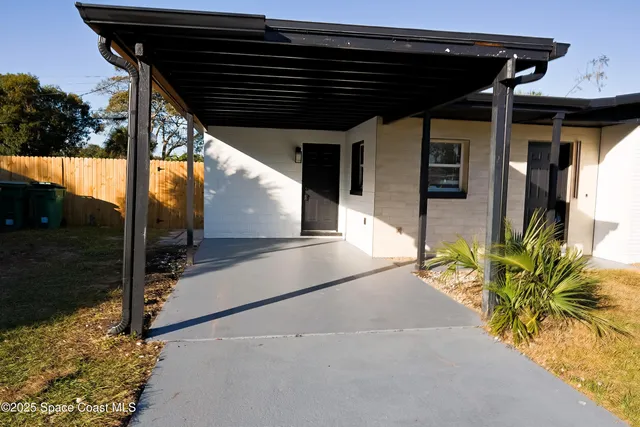a patio with table and chairs and potted plants