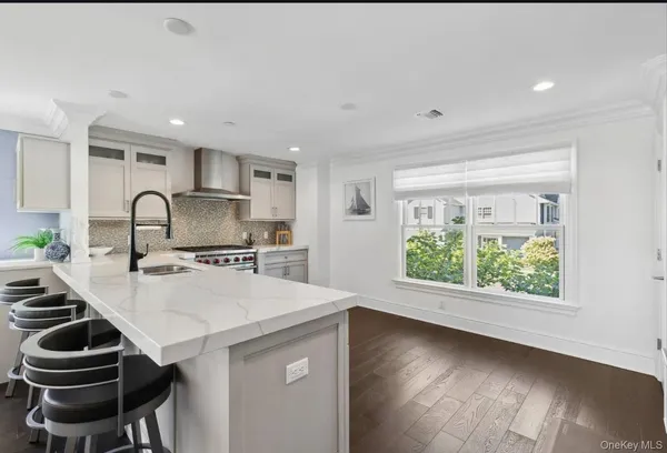 a kitchen with a sink a stove a refrigerator cabinets and a window