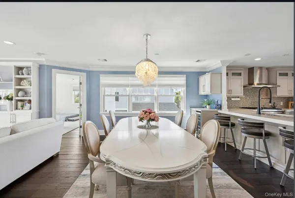 a dining room with furniture a chandelier and wooden floor