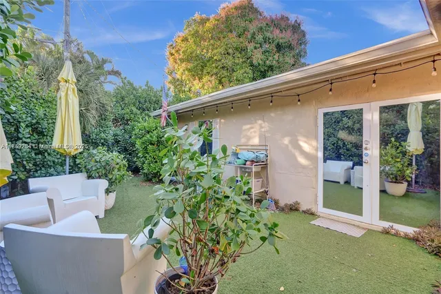 a view of a chair and table in the back yard of a house