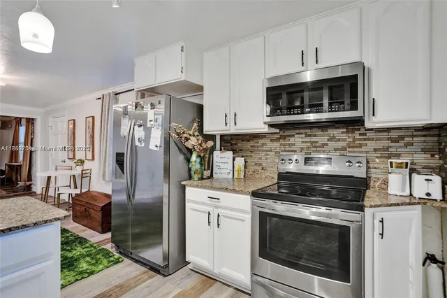 a kitchen with stainless steel appliances granite countertop a stove a microwave and a refrigerator