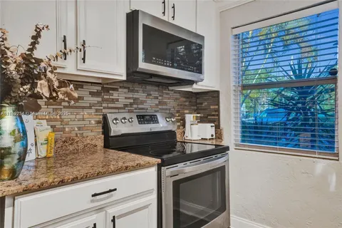 a kitchen with stainless steel appliances granite countertop a stove a microwave and a sink