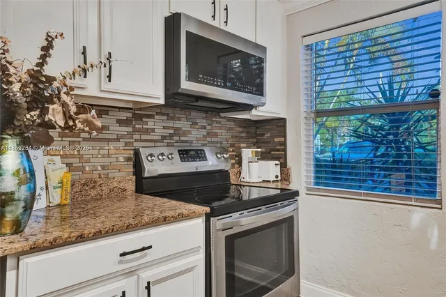 a kitchen with stainless steel appliances granite countertop a stove a microwave and a sink