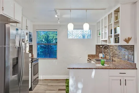 a kitchen with stainless steel appliances granite countertop a refrigerator and a sink