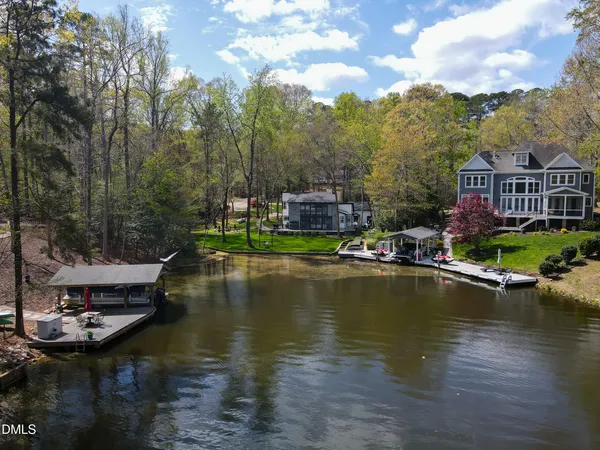 an aerial view of a house with a yard and lake view