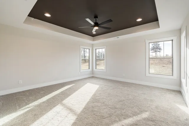 an empty room with windows and ceiling fan