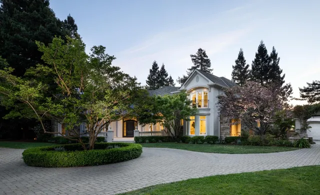 a front view of a house with a yard and trees