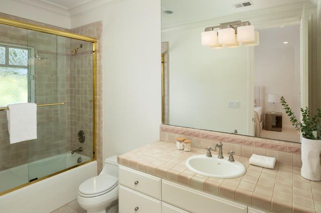 a bathroom with a granite countertop sink toilet a mirror and shower