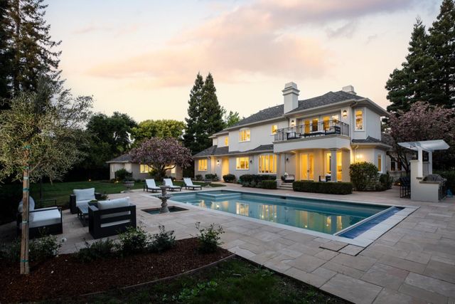 a view of a house with swimming pool and sitting area