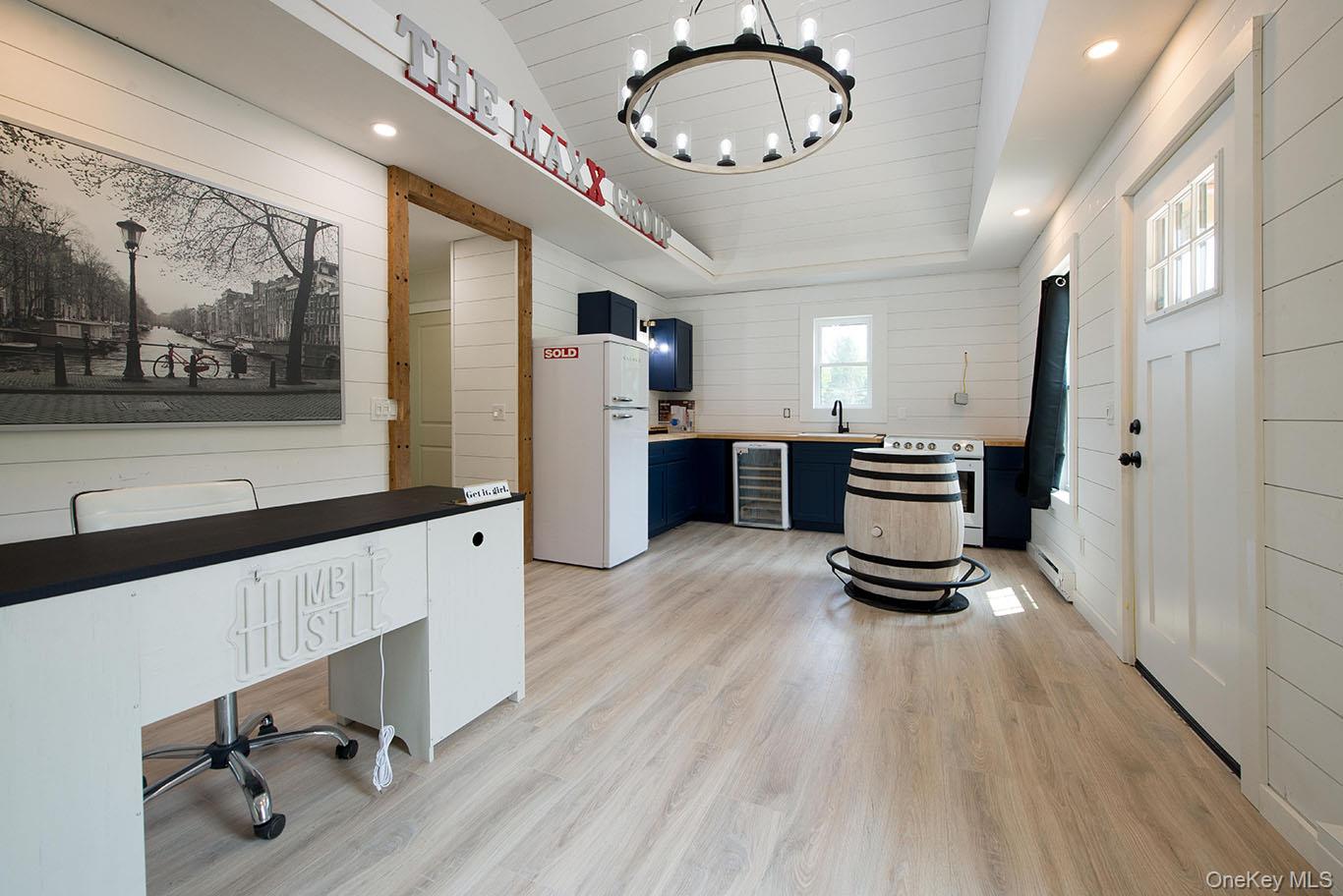 1132 Old Rte 17 Harris, NY 12742 - Photo 19 of 26 Unfurnished office featuring wooden walls, light wood-style flooring, wine cooler, recessed lighting, and a chandelier