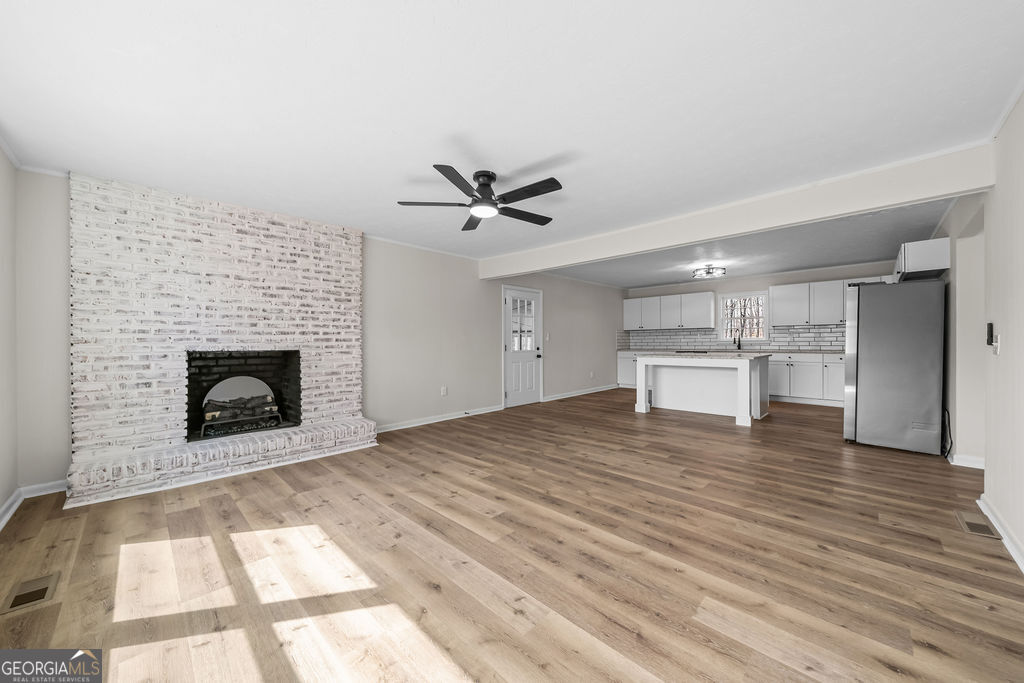 18 Holder Road Temple, GA 30179 - Photo 11 of 44 a view of a livingroom with a fireplace a ceiling fan and wooden floor