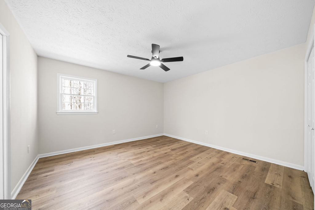 18 Holder Road Temple, GA 30179 - Photo 18 of 44 an empty room with wooden floor and ceiling fan