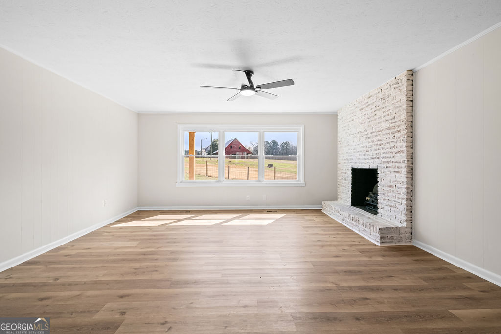 18 Holder Road Temple, GA 30179 - Photo 10 of 44 an empty room with wooden floor fireplace and windows