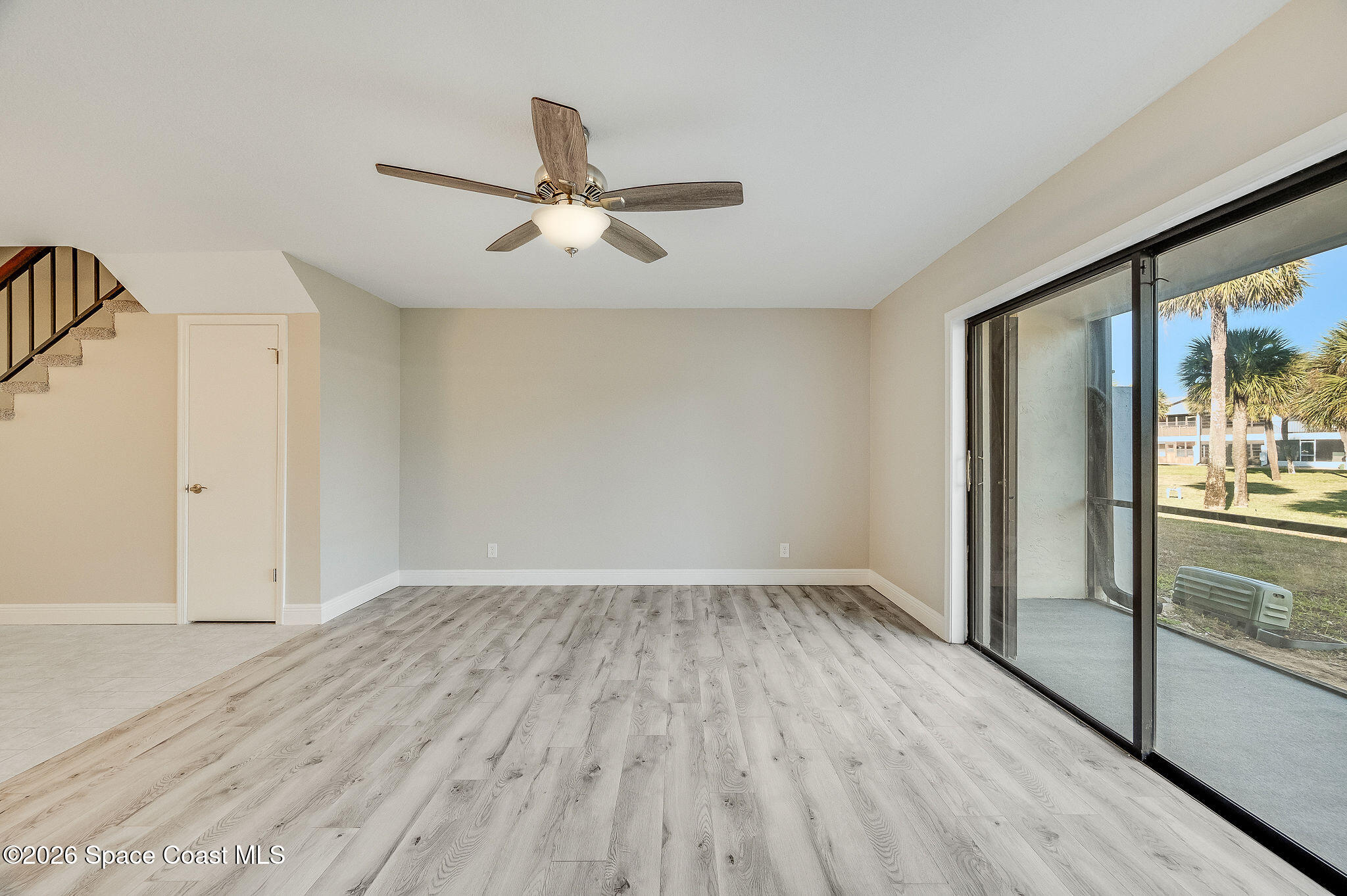 720 Palm Springs Circle Indian Harbour Beach, FL 32937 - Photo 19 of 57 an empty room with wooden floor fan and windows