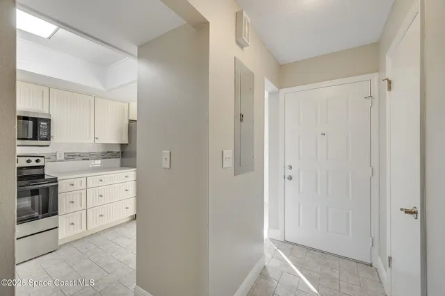 a kitchen with white cabinets and appliances