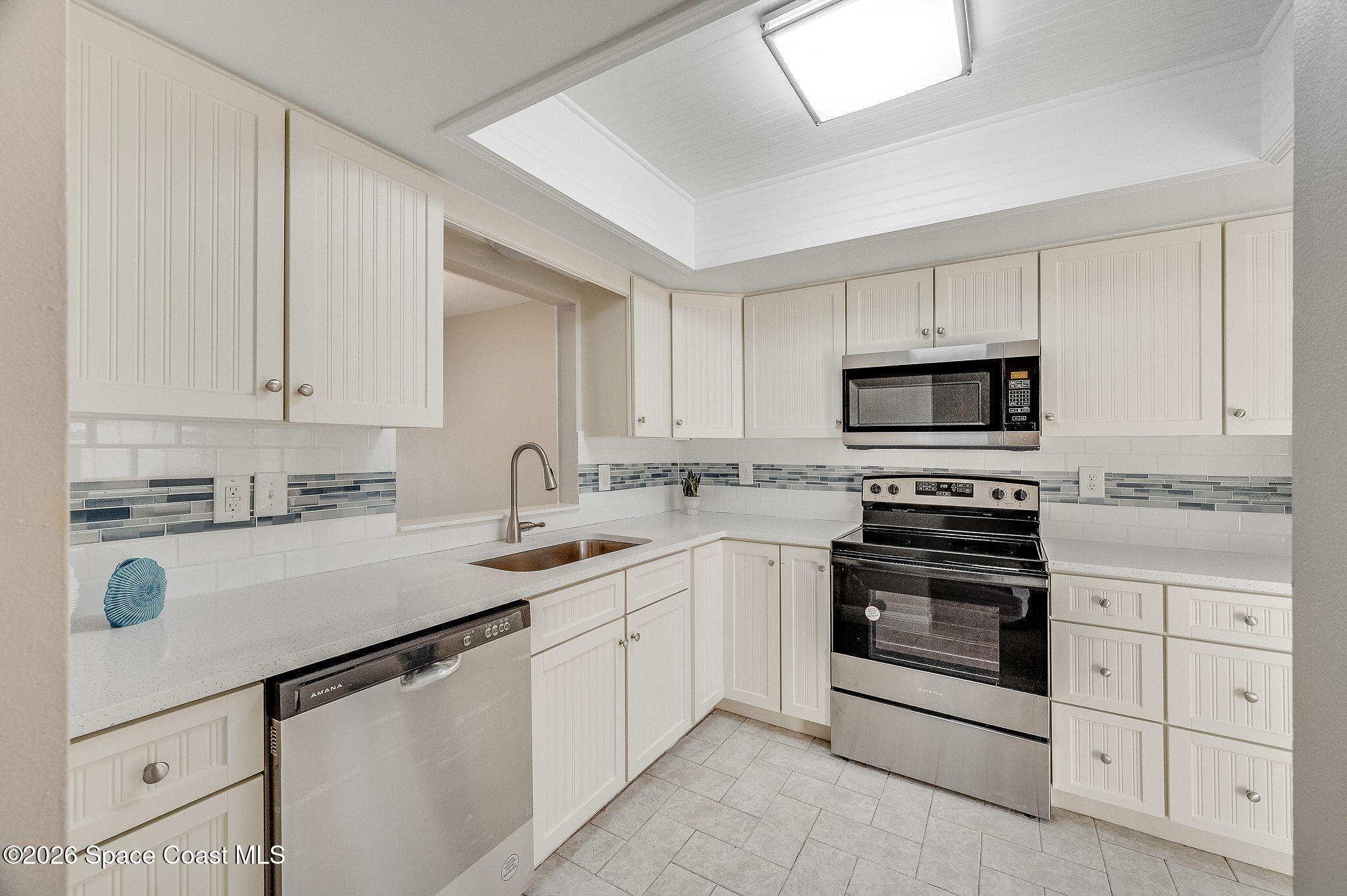 720 Palm Springs Circle Indian Harbour Beach, FL 32937 - Photo 5 of 57 a kitchen with white cabinets appliances and sink