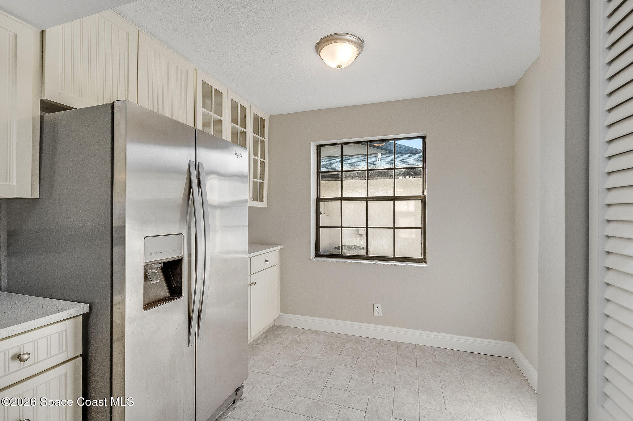 720 Palm Springs Circle Indian Harbour Beach, FL 32937 - Photo 7 of 57 a kitchen with a refrigerator and white cabinets