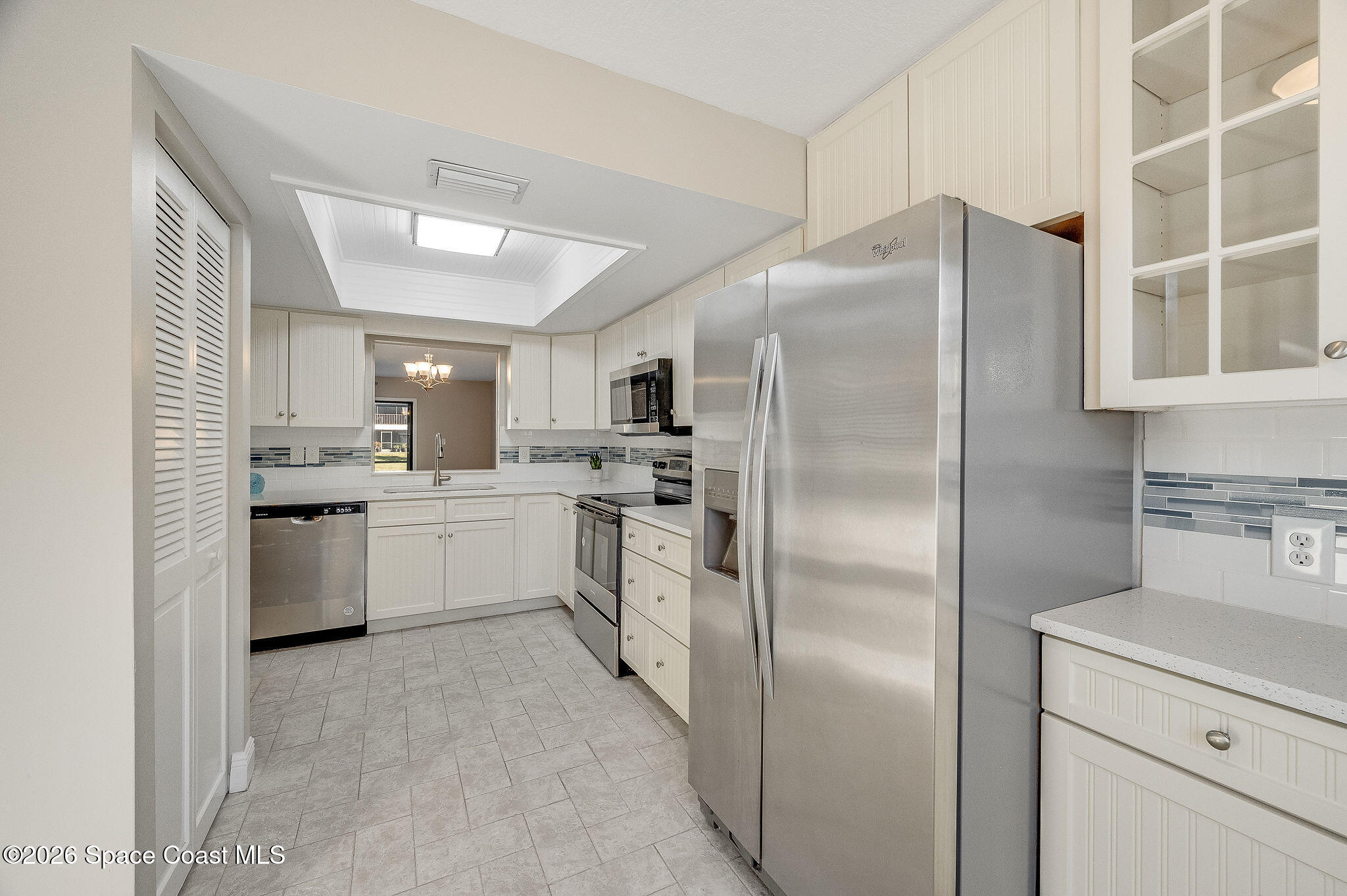 720 Palm Springs Circle Indian Harbour Beach, FL 32937 - Photo 8 of 57 a kitchen with a refrigerator a sink and dishwasher with white cabinets