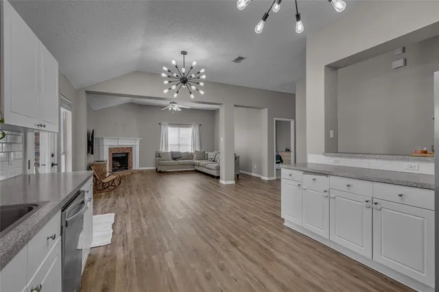 a view of a livingroom with furniture wooden floor and a chandelier