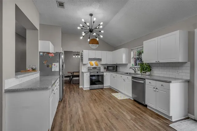 a kitchen with cabinets a sink and appliances