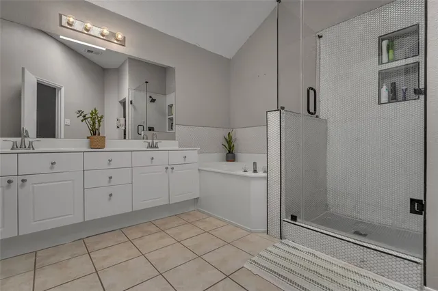 a spacious bathroom with a double vanity sink a mirror and a shower