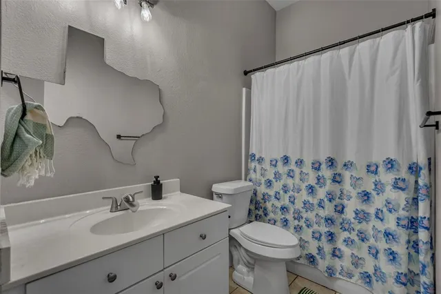 a bathroom with a sink a toilet and a mirror