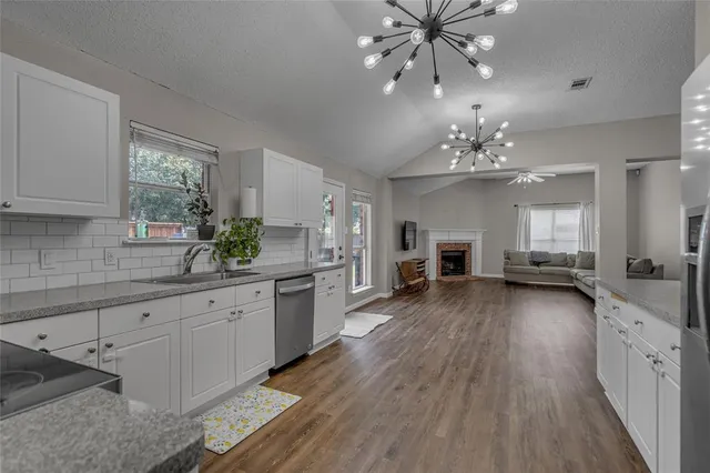 a large kitchen with a lot of counter space and wooden floor