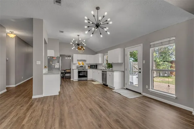 a view of a kitchen with cabinets and wooden floor