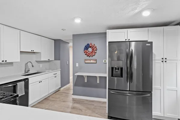 a kitchen with stainless steel appliances a refrigerator sink and cabinets