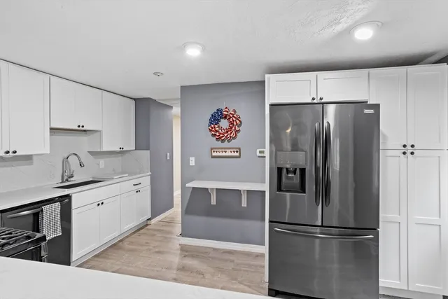 a kitchen with stainless steel appliances a refrigerator sink and cabinets