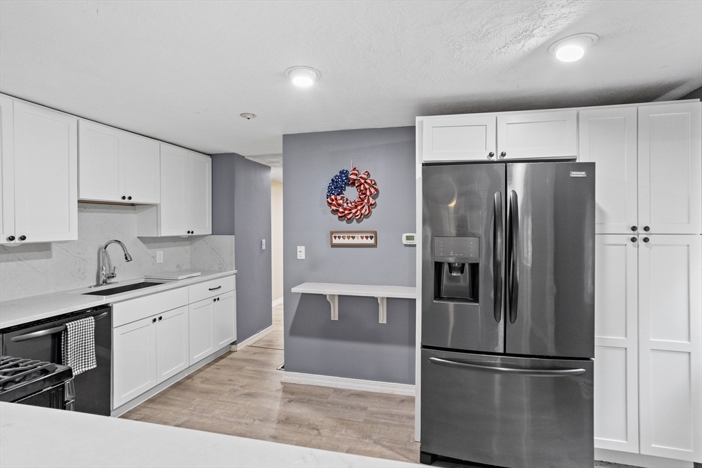16 Middlesex Street, Unit 4 Chelmsford, MA 01863 - Photo 11 of 25 a kitchen with stainless steel appliances a refrigerator sink and cabinets