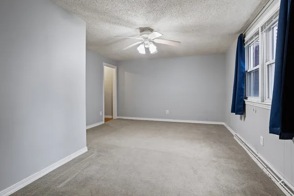 a view of an empty room with a chandelier fan