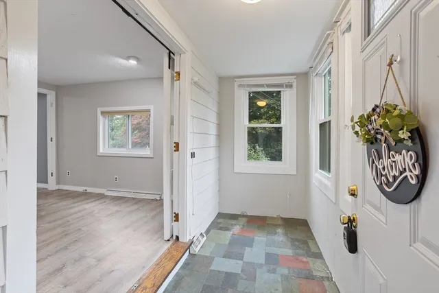 an entryway with wooden floor and windows