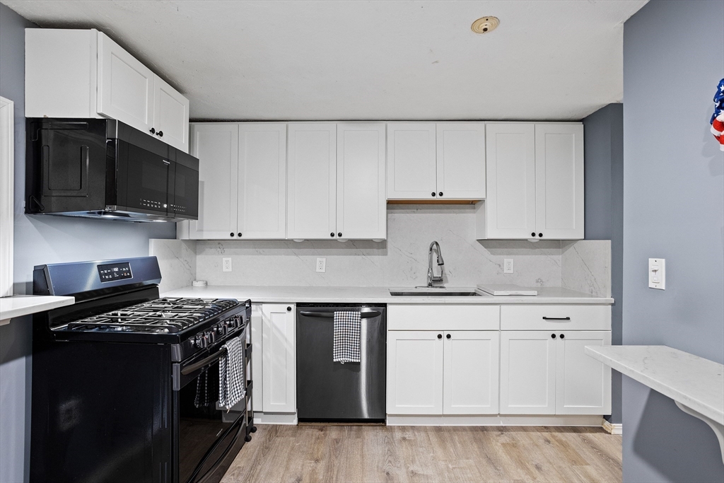 16 Middlesex Street, Unit 4 Chelmsford, MA 01863 - Photo 8 of 25 a kitchen with granite countertop a sink and a stove top oven