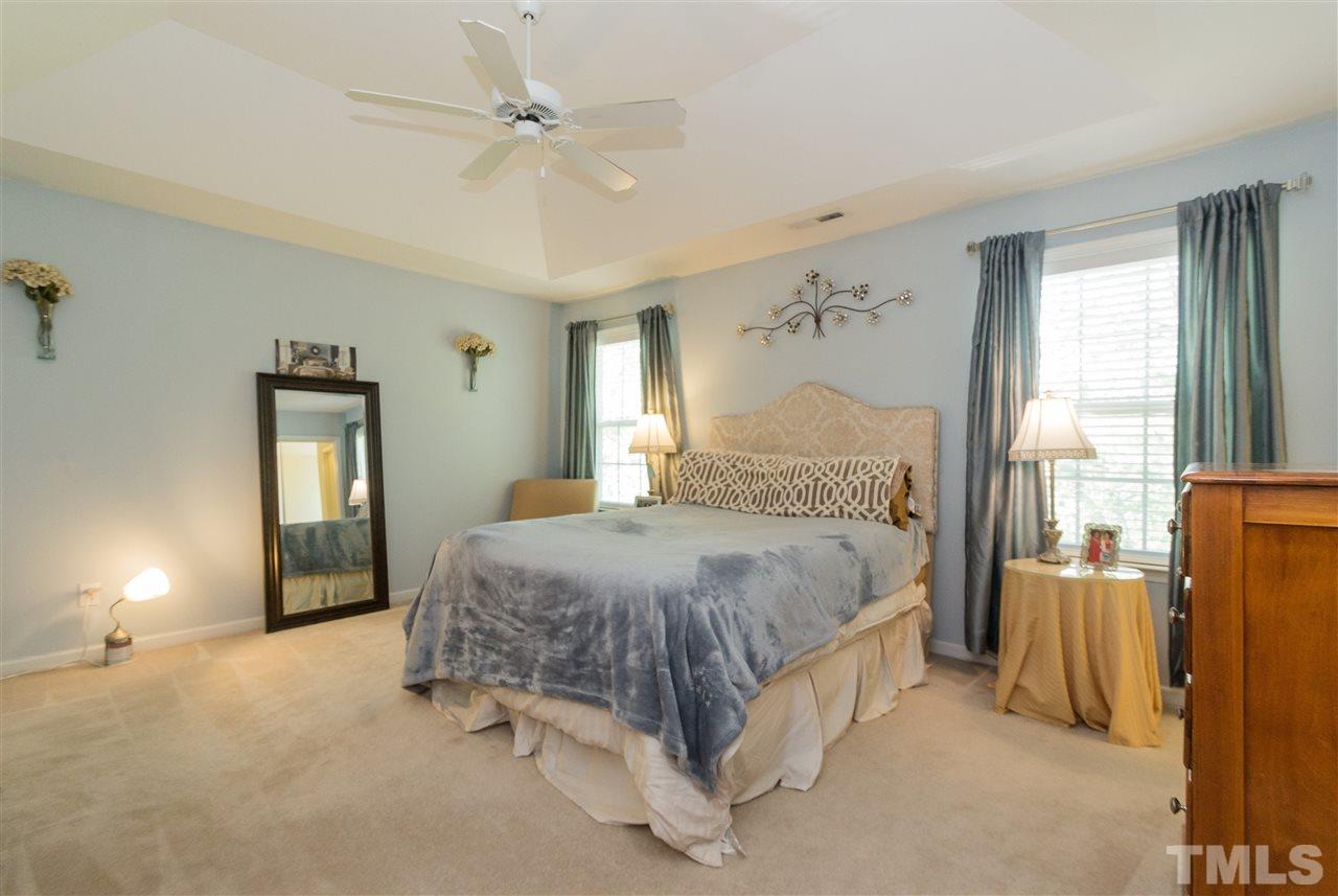 4809 Hodfield Court Raleigh, NC 27604 - Photo 13 of 22 a spacious bedroom with a bed and a lamp