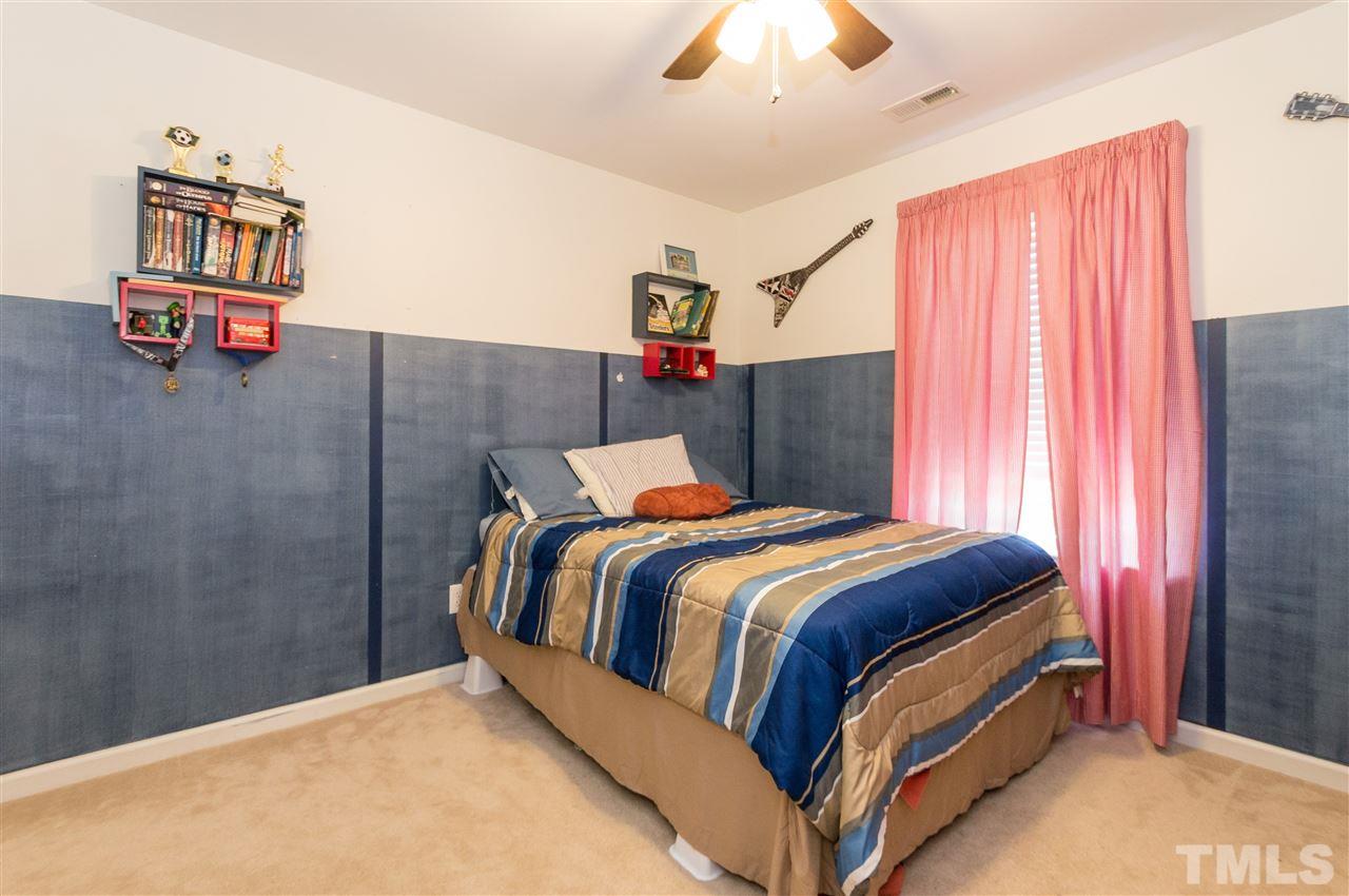 4809 Hodfield Court Raleigh, NC 27604 - Photo 17 of 22 a bedroom with a bed and a chandelier